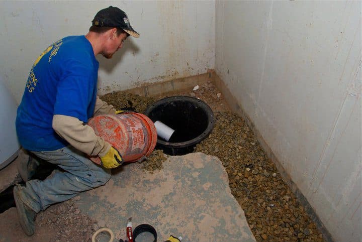 The Main Line Waterproofing team at work installing a basement french drain (pressure relief system) inside a home.
