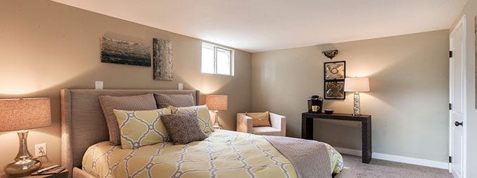 Comfortable finished basement bedroom made possible through basement lowering